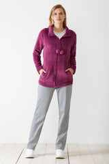 Eine Fleecejacke für Damen mit durchgehendem Reißverschluss in leuchtendem Magenta, mit Stehkragen und zwei dekorativen Bommeln am Halsausschnitt.