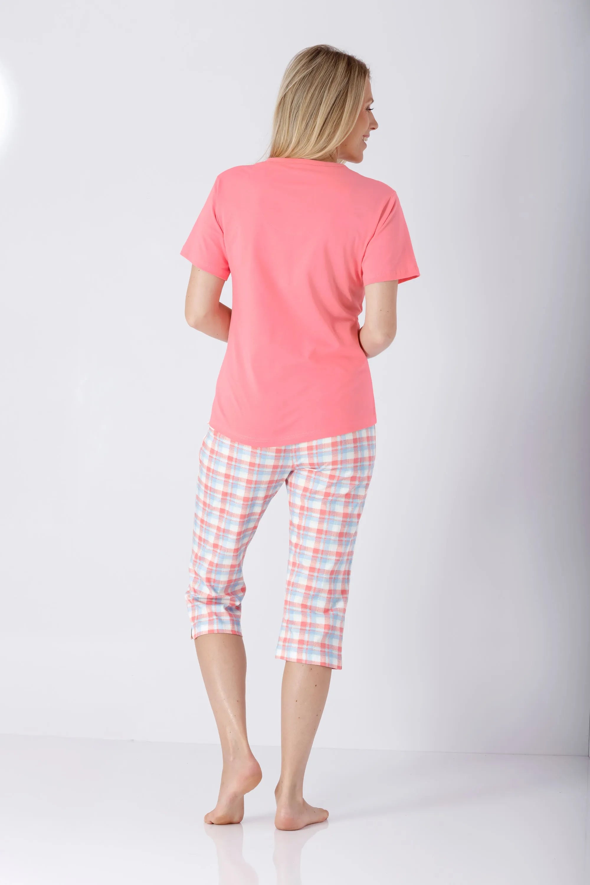 Frau in koralle rosa Top und pastell Karo Capri Schlafanzug aus Premium Cotton