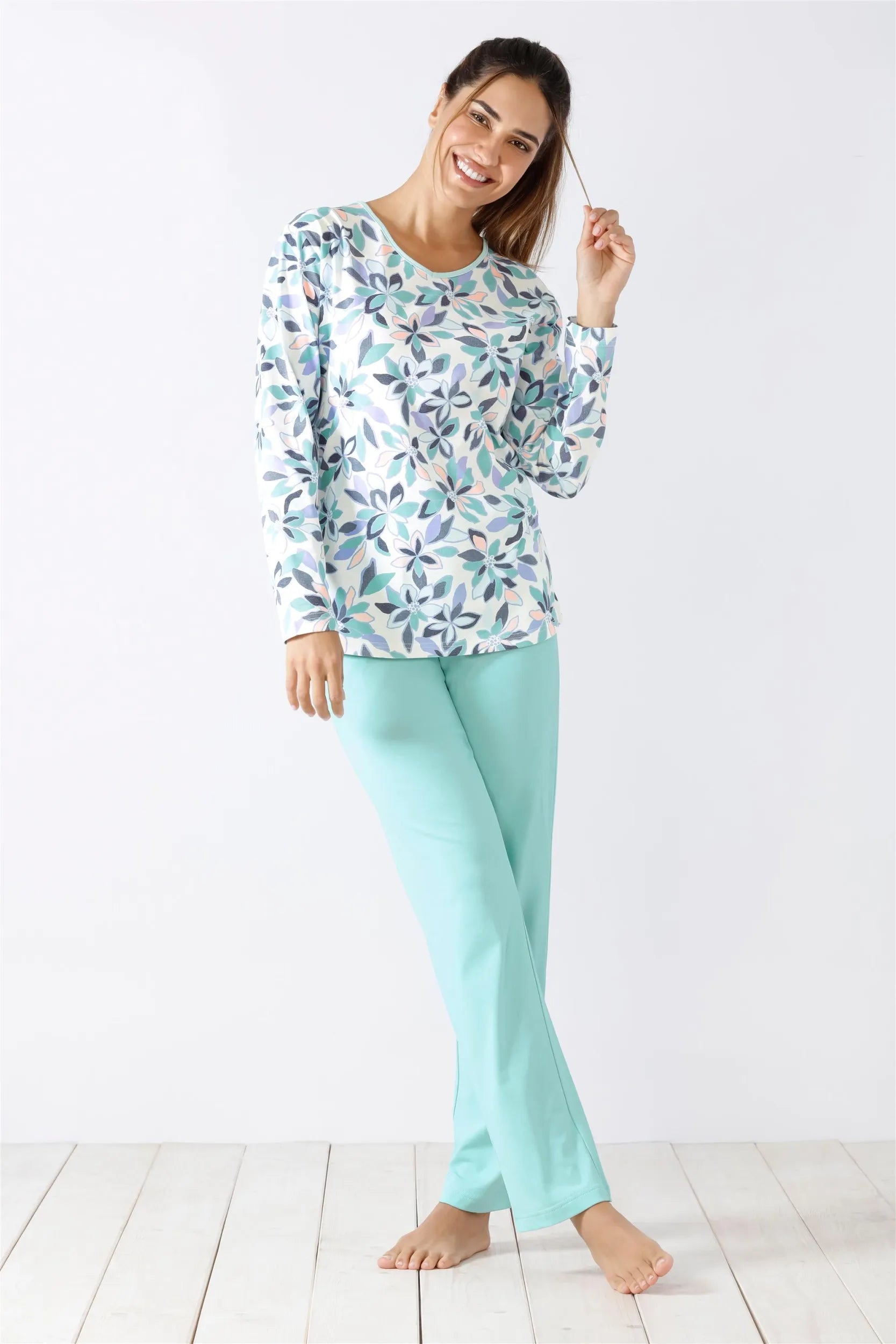 Langärmeliges Damen-Pyjama-Oberteil mit Blumenmuster und einfarbige mintgrüne Pyjama-Hose.
