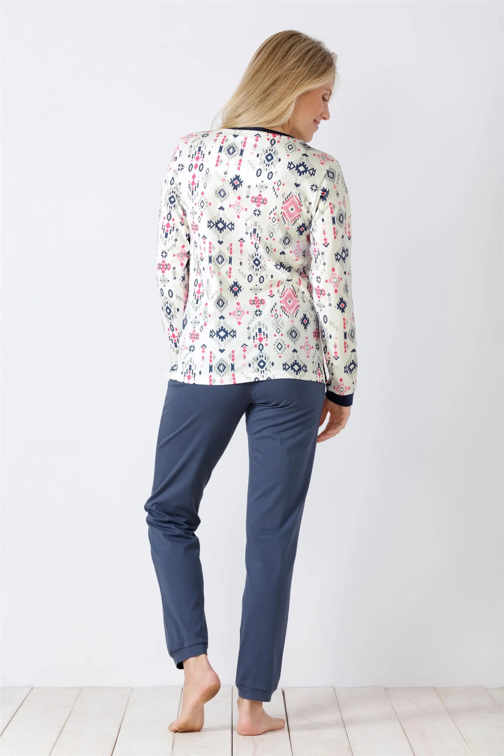 Gemustertes langärmeliges Damen-Pyjama-Oberteil und einfarbig blaue Pyjama-Hose.