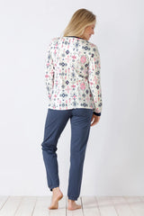 Gemustertes langärmeliges Damen-Pyjama-Oberteil und einfarbig blaue Pyjama-Hose.