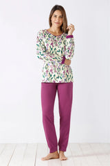 Gemustertes langärmeliges Damen-Pyjama-Oberteil und einfarbige magentafarbene Pyjama-Hose.