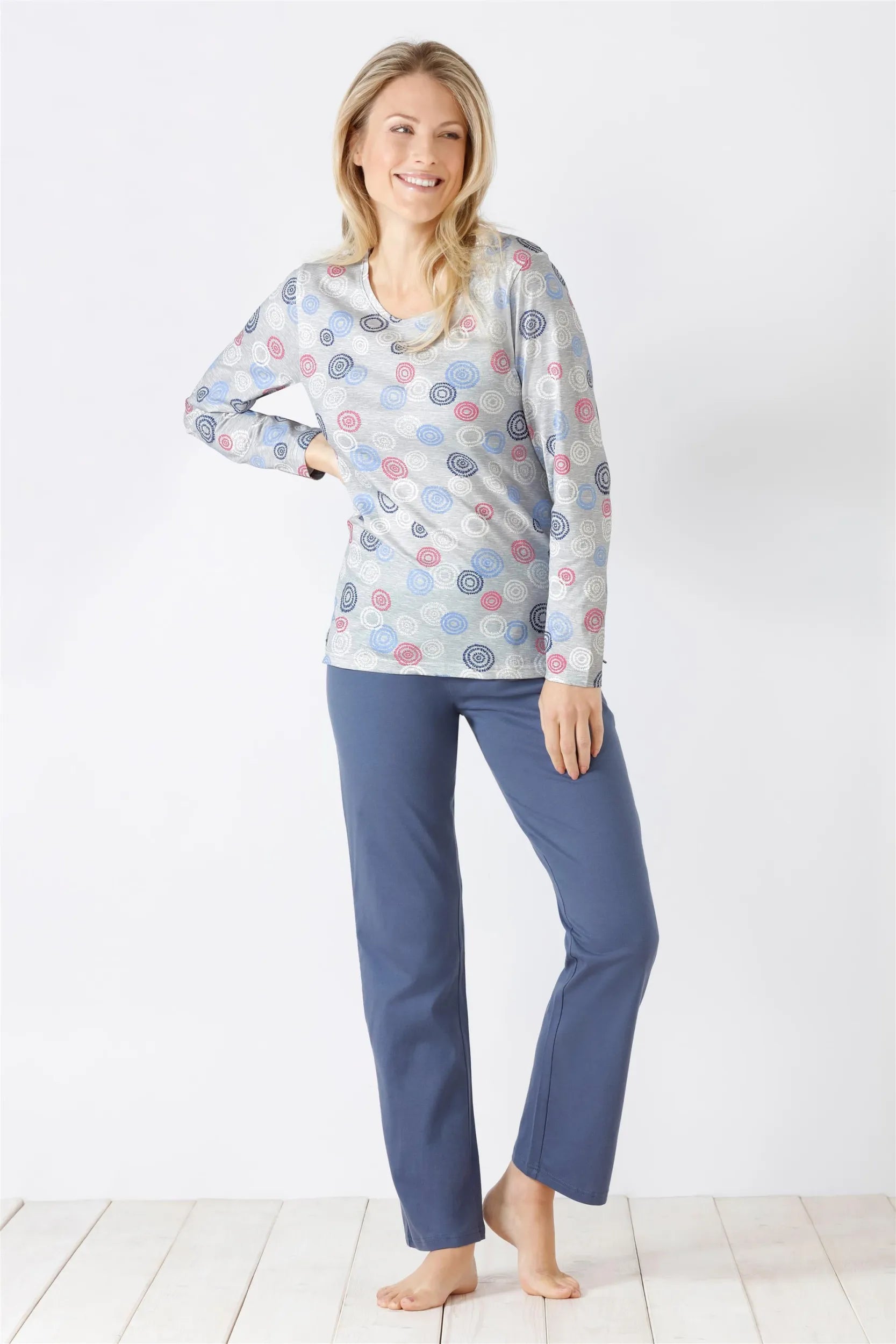 Langärmeliges gemustertes Damen-Pyjama-Oberteil mit einfarbig blauer Pyjama-Hose.