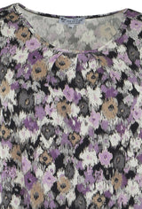 Tank-Top mit Blumendruck mit lila, weißen und grauen Blumen auf schwarzem Hintergrund.