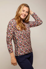 Bluse mit Blumenmuster und langen Ärmeln und marineblaue Hose.