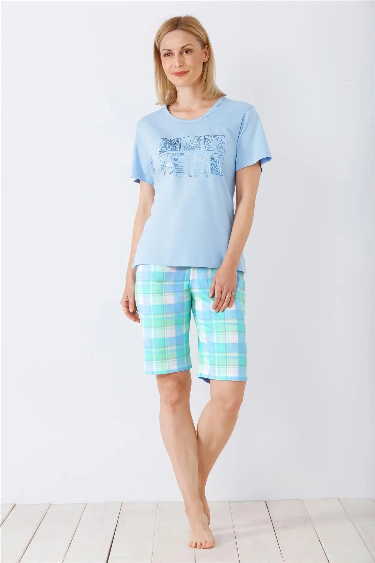 Hellblaues kurzärmeliges Pyjama-Oberteil mit gemusterten Shorts.