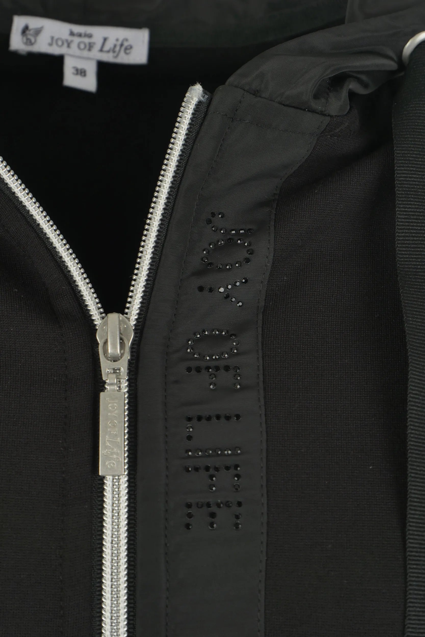 Schwarze Reißverschlussjacke mit silbernem Reißverschluss und strassbesetztem ’Lebensfreude’-Design auf der Vorderseite.