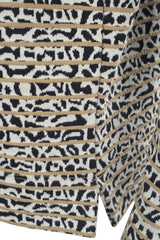 Gemusterter Stoff mit Leopardenmuster in den Farben Schwarz, Weiß und Beige.
