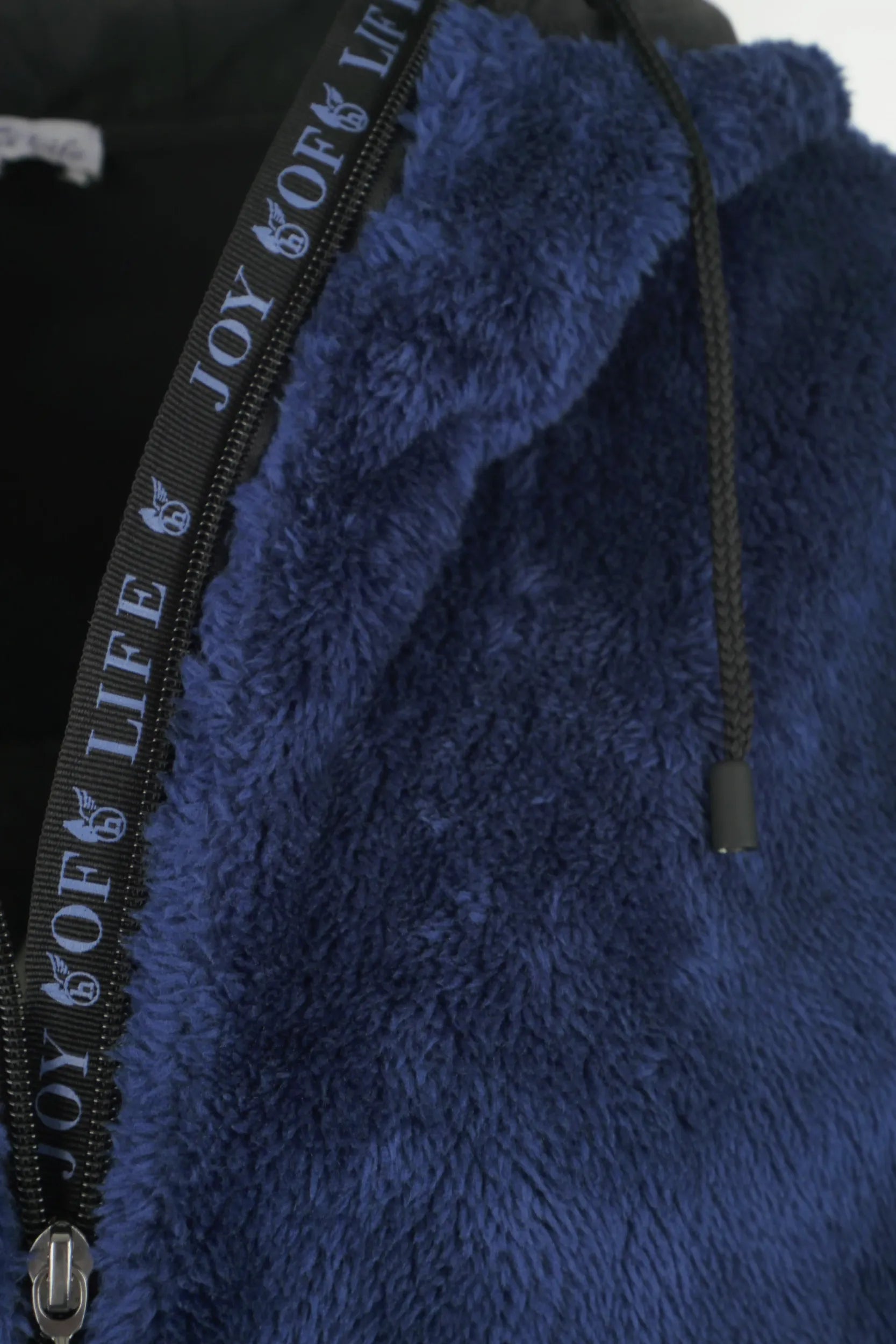 Blauer, flauschiger Kapuzenpulli mit dem Text ’Lebensfreude’ auf dem Reißverschluss.