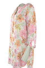 Langärmeliges Kleid mit Blumendruck, weißem Hintergrund und Pastellfarben.