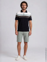 Schwarzweiß gestreiftes polohemd mit marineblauen akzenten kombiniert mit elastischer bermudashort mit cargotaschen