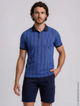 Blaue gemusterte poloshirt mit schwarzem kragen und ärmelabschluss zur elastischen bermudashort mit cargotaschen