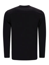 Schwarzer Rollkragenpullover mit gerippten Bündchen und Saum, wahrscheinlich aus Baumwolle oder Wolle gefertigt.
