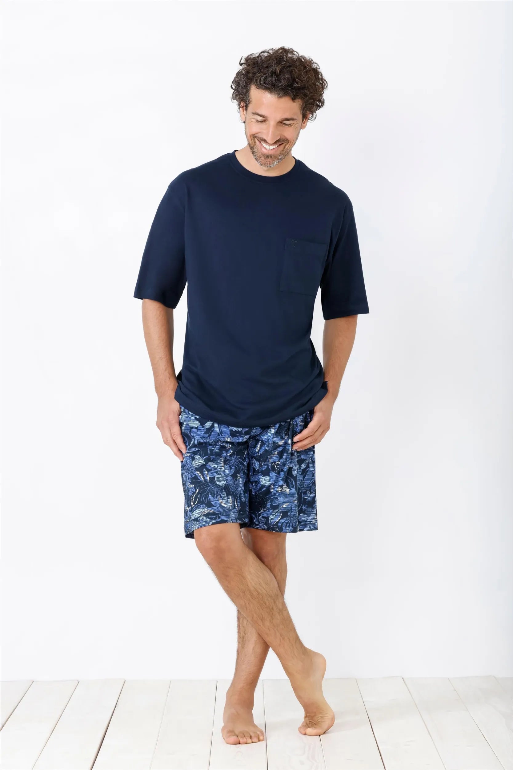 Marineblaues, kurzärmeliges T-Shirt und geblümte Shorts als Schlafanzug für einen Mann.