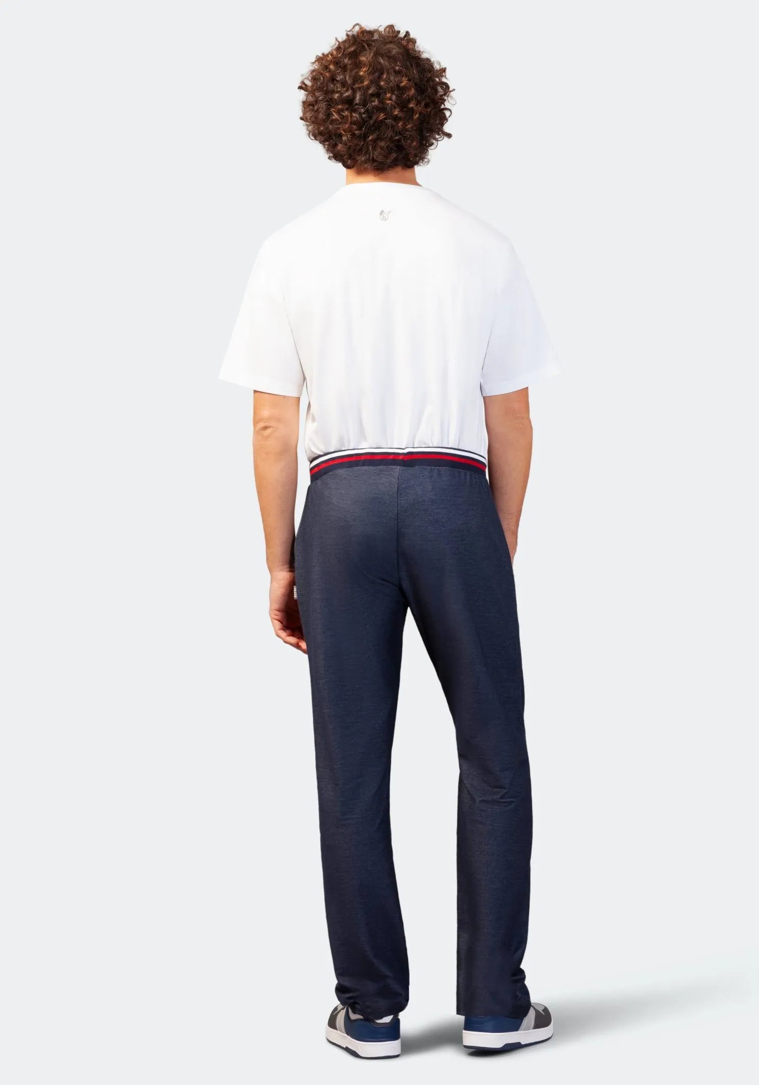 Marineblaue, schmal geschnittene Chinohose mit rotem Bund und weißem Logo auf der Rückseite