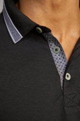 Schwarzes Poloshirt mit weißen Knöpfen und gemustertem Kragen