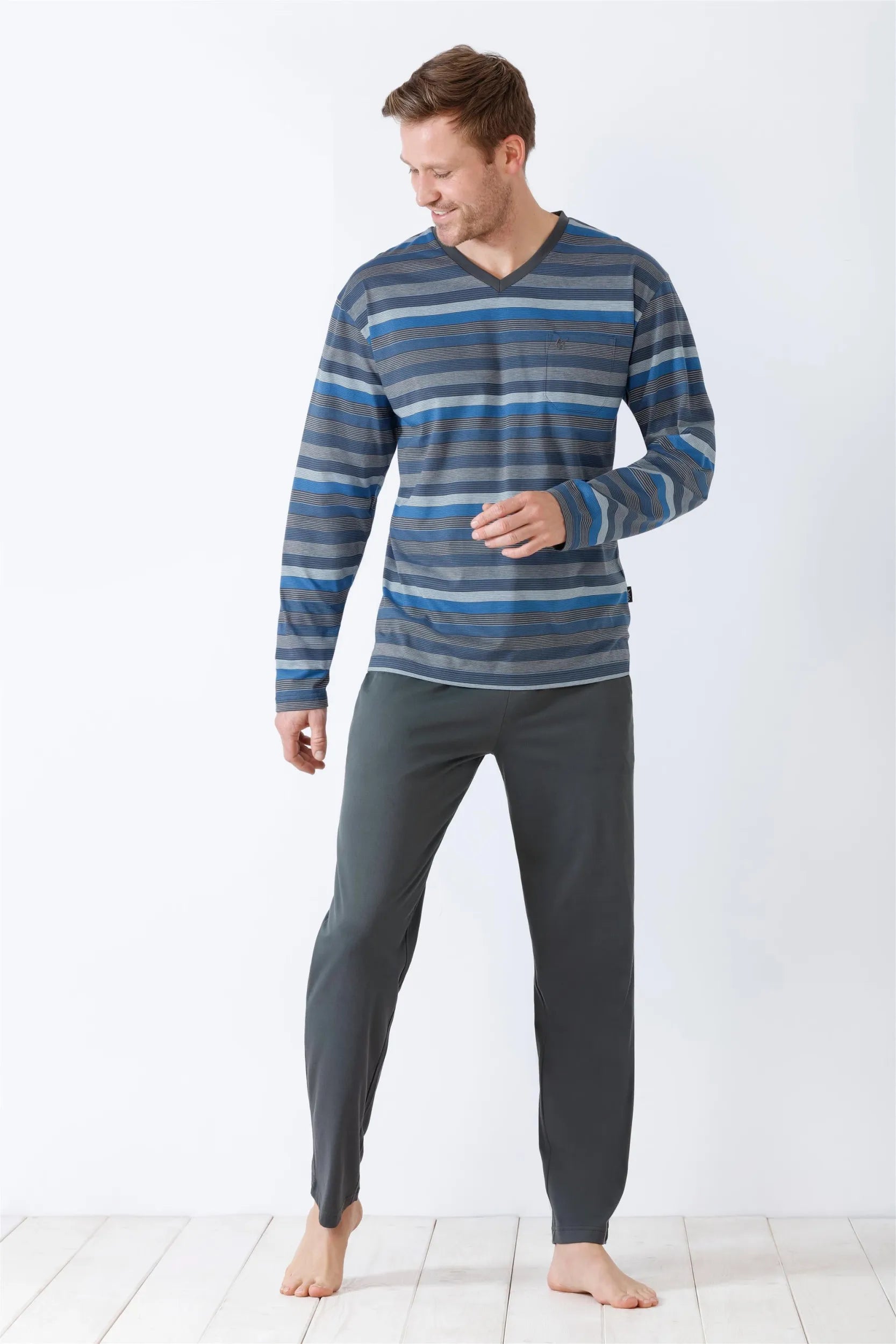 Blau-grau-weiß gestreiftes Langarmshirt mit V-Ausschnitt und dunkelgraue Jogginghose für Herren.