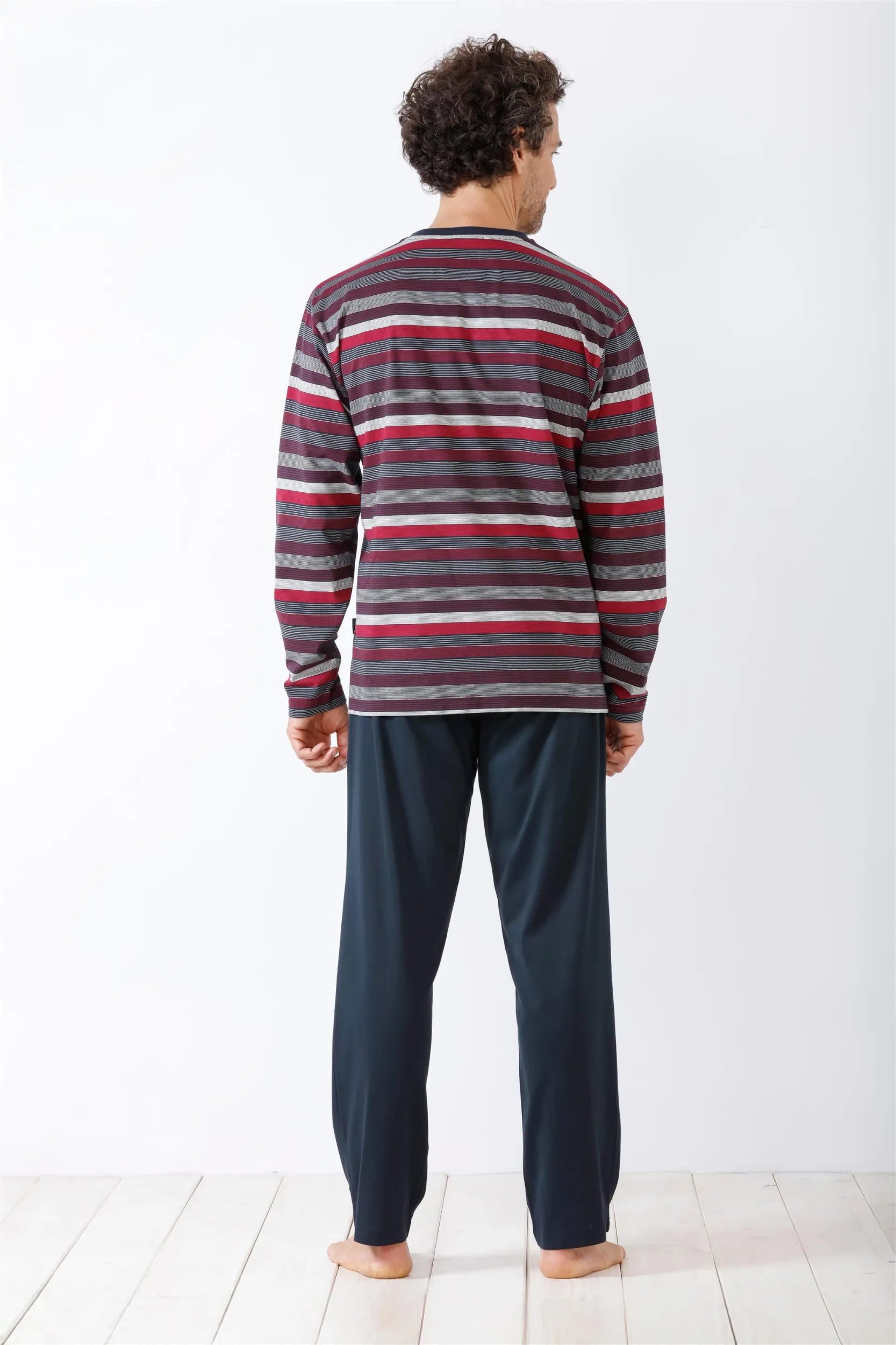 Langärmeliges gestreiftes Pyjama-Oberteil und einfarbige dunkelblaue Pyjama-Hose für Männer.
