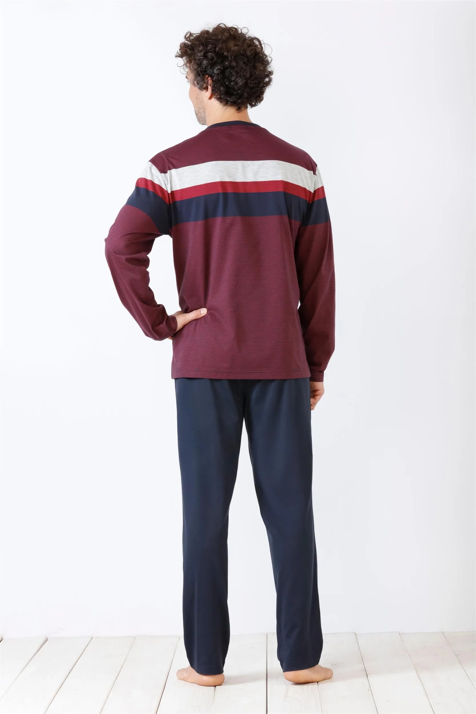 Kastanienbraunes langärmeliges Herrenhemd mit horizontalen weißen und marineblauen Streifen und marineblauer Hose.