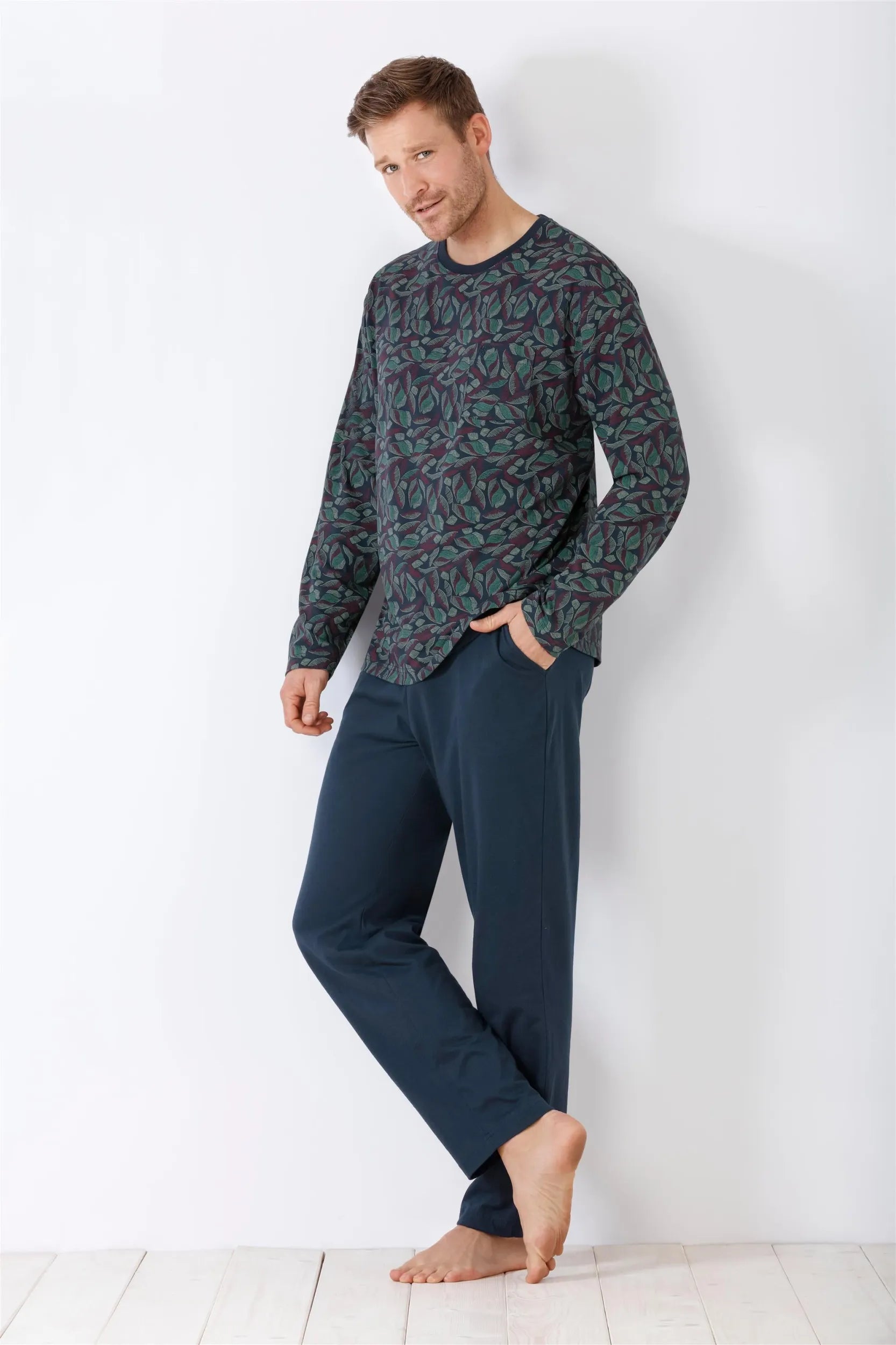 Langärmeliges gemustertes Pyjama-Oberteil und einfarbige blaue Pyjama-Hose für Männer.
