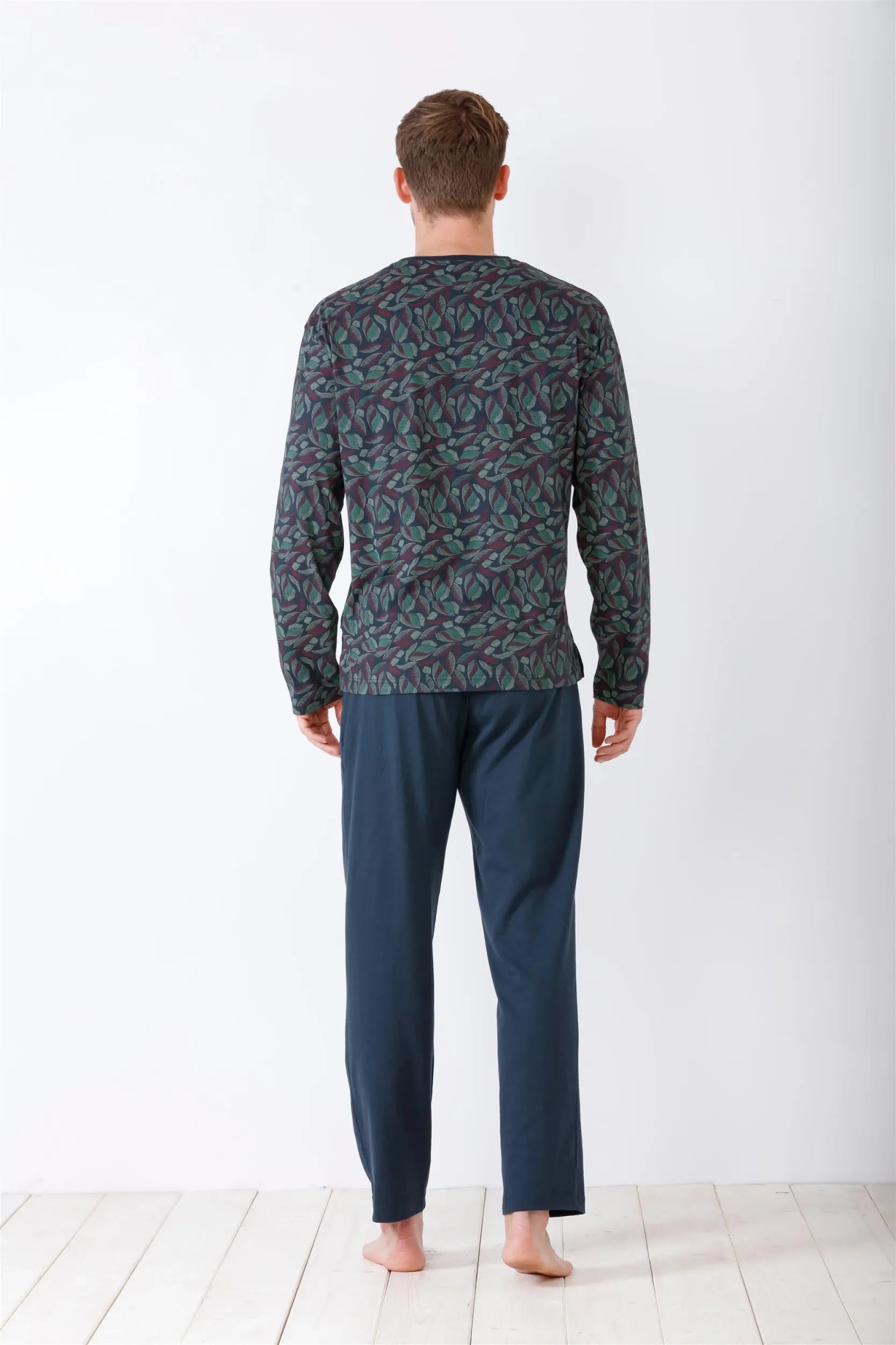 Dunkelgrünes, langärmeliges, gemustertes Herren-Pyjama-Oberteil mit einfarbiger dunkelblauer Pyjama-Hose.