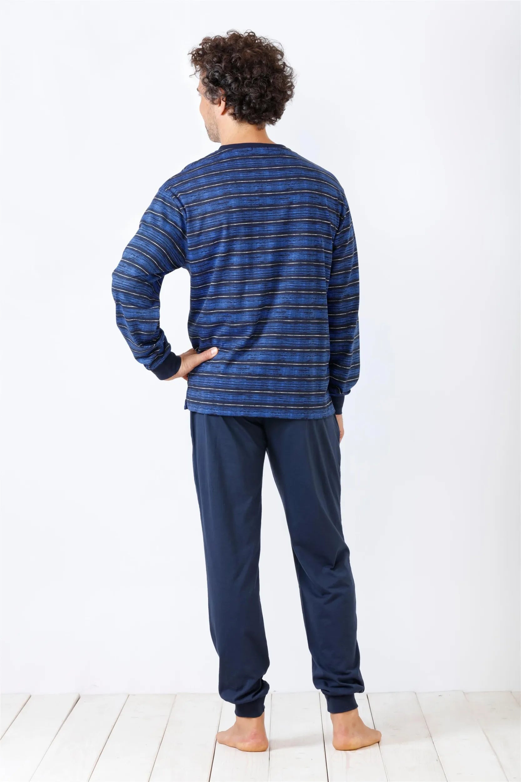 Blau gestreiftes langärmeliges Schlafanzugoberteil und einfarbig blaue Schlafanzughose für Männer.