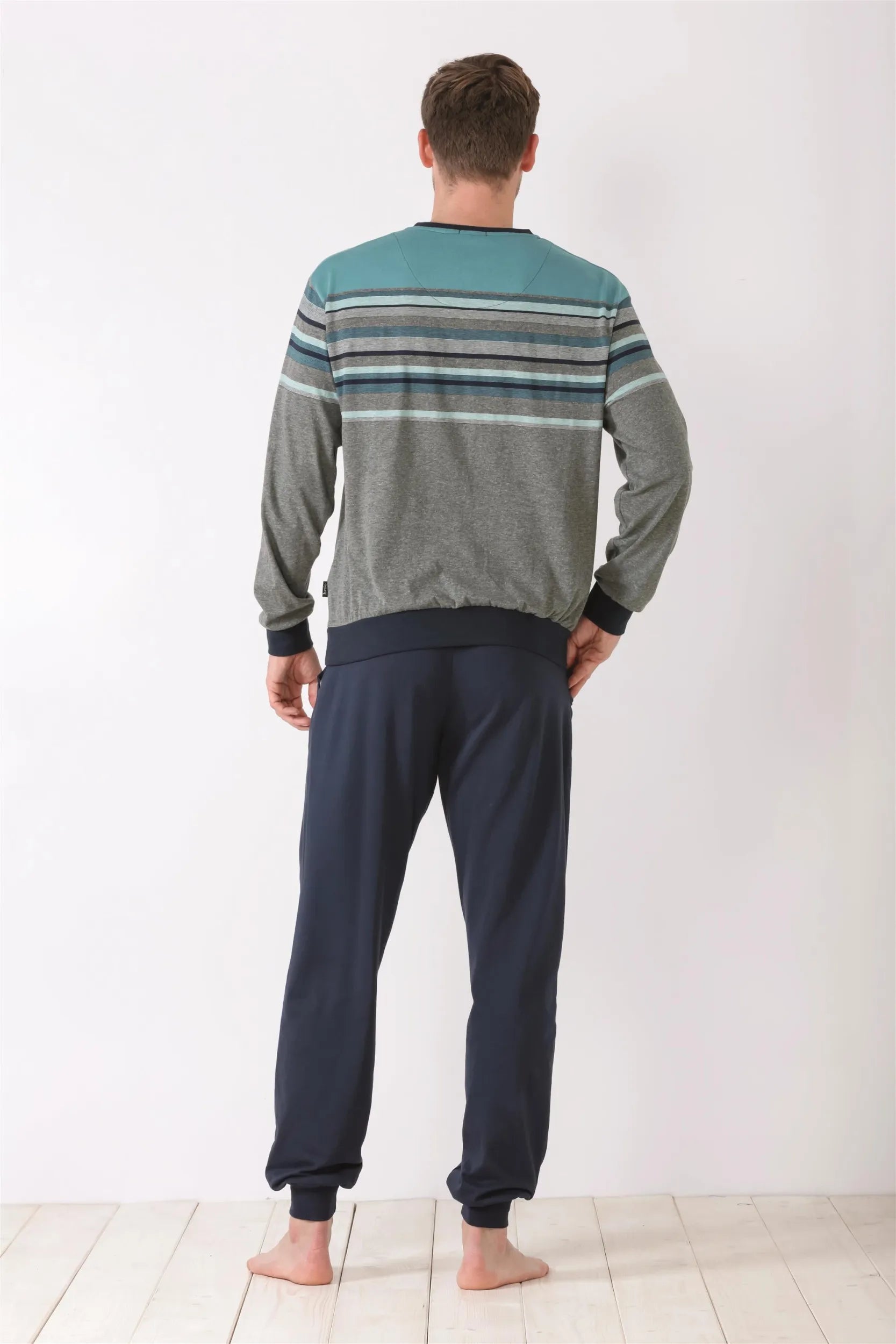 Langärmeliges gestreiftes Pyjama-Oberteil und einfarbige dunkelblaue Pyjama-Hose für Männer.