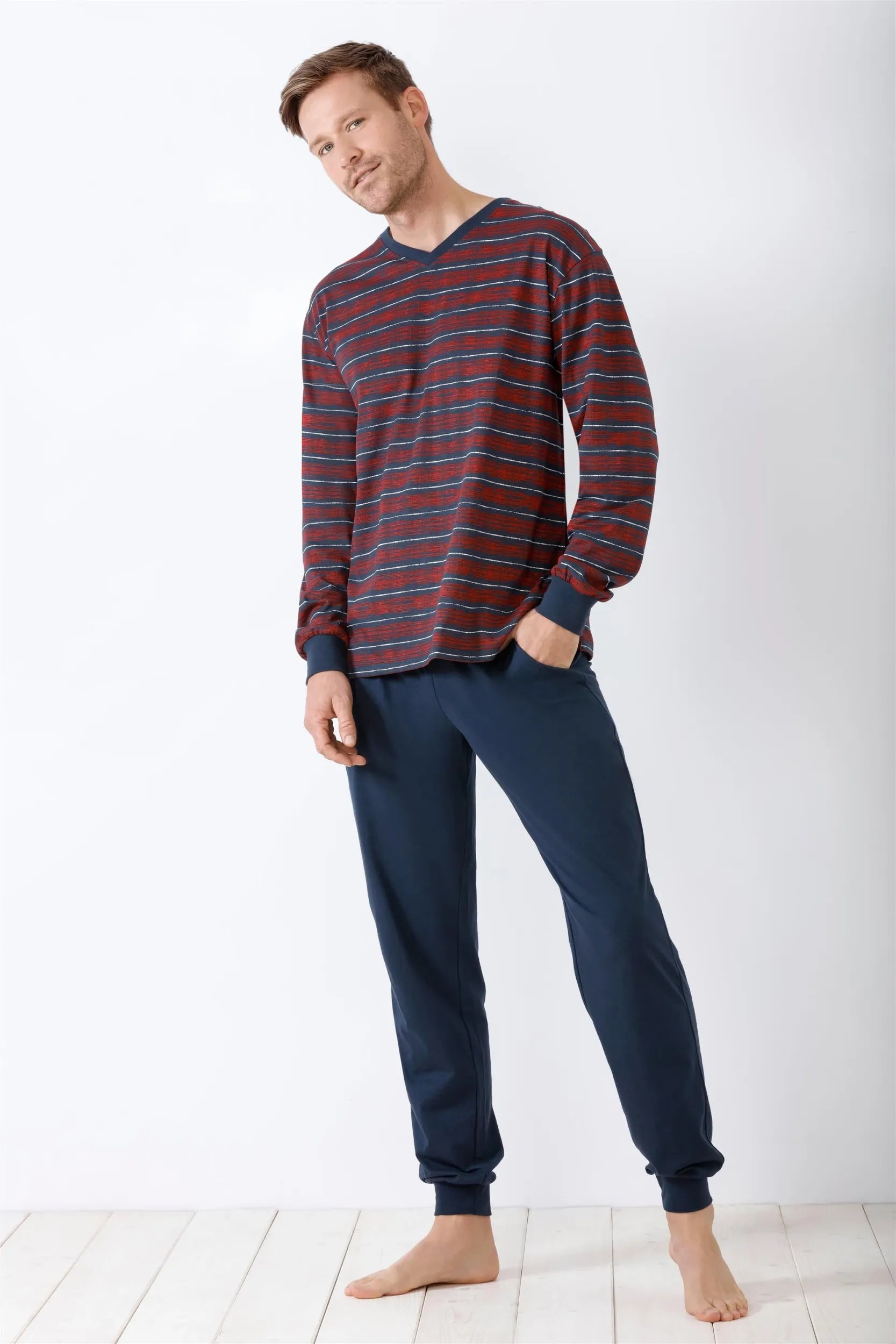 Rot und blau gestreiftes langärmeliges Herren-Pyjama-Oberteil mit marineblauer Pyjama-Hose.