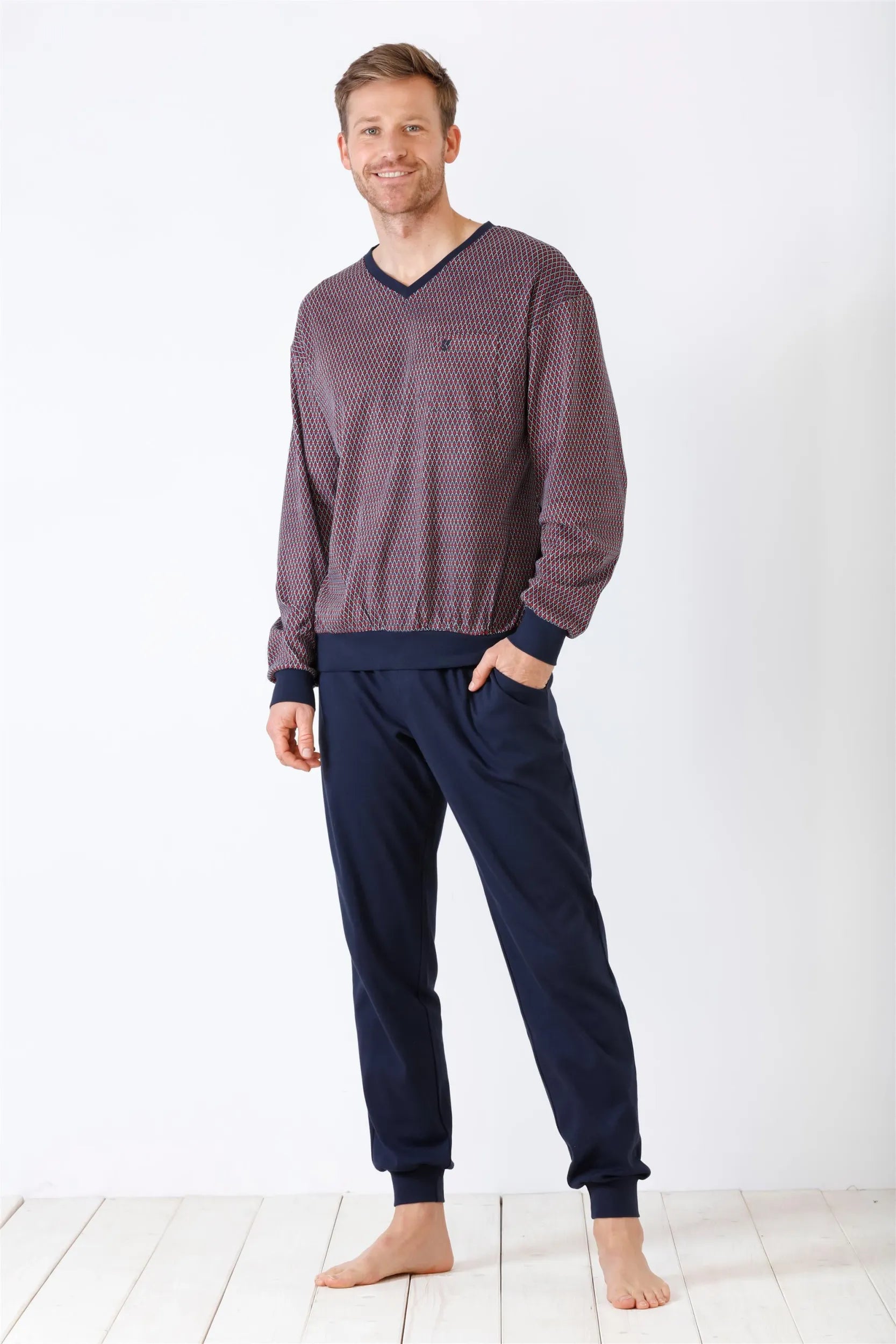 Gemustertes langärmeliges Herren-Pyjama-Oberteil mit einfarbiger dunkelblauer Pyjama-Hose.