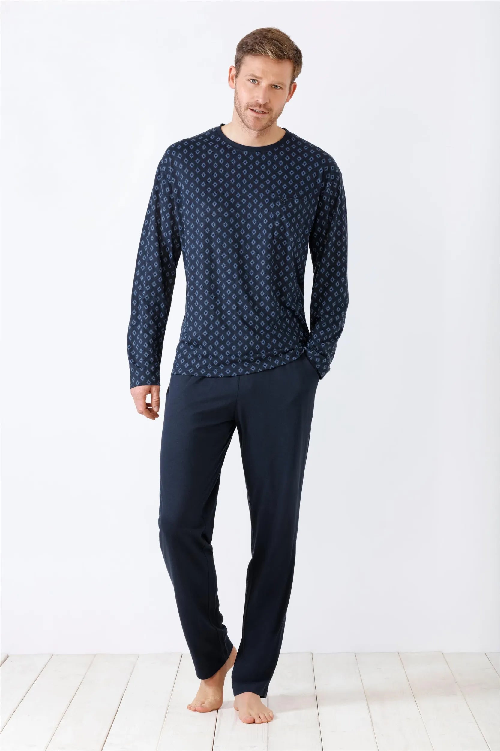 Dunkelblaues langärmeliges Herrenhemd mit geometrischem Muster und einfarbige dunkelblaue Hose.