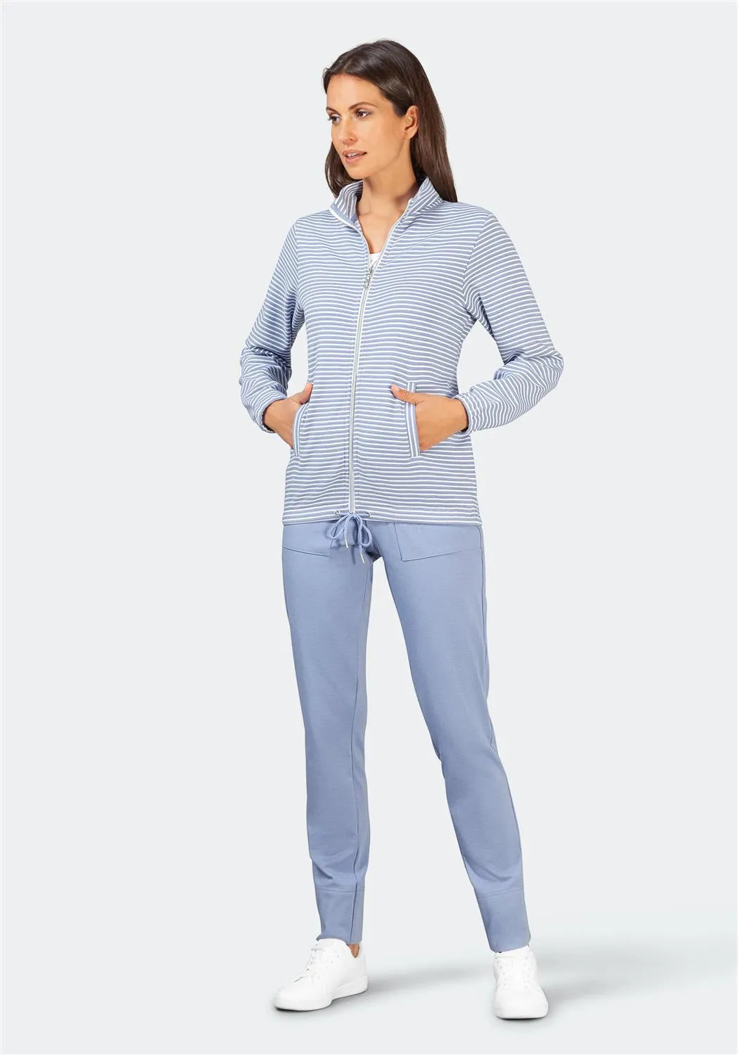 Blau-weiß gestreifter Kapuzenpulli mit Kordelzug, hellblaue Hose, weiße Turnschuhe.