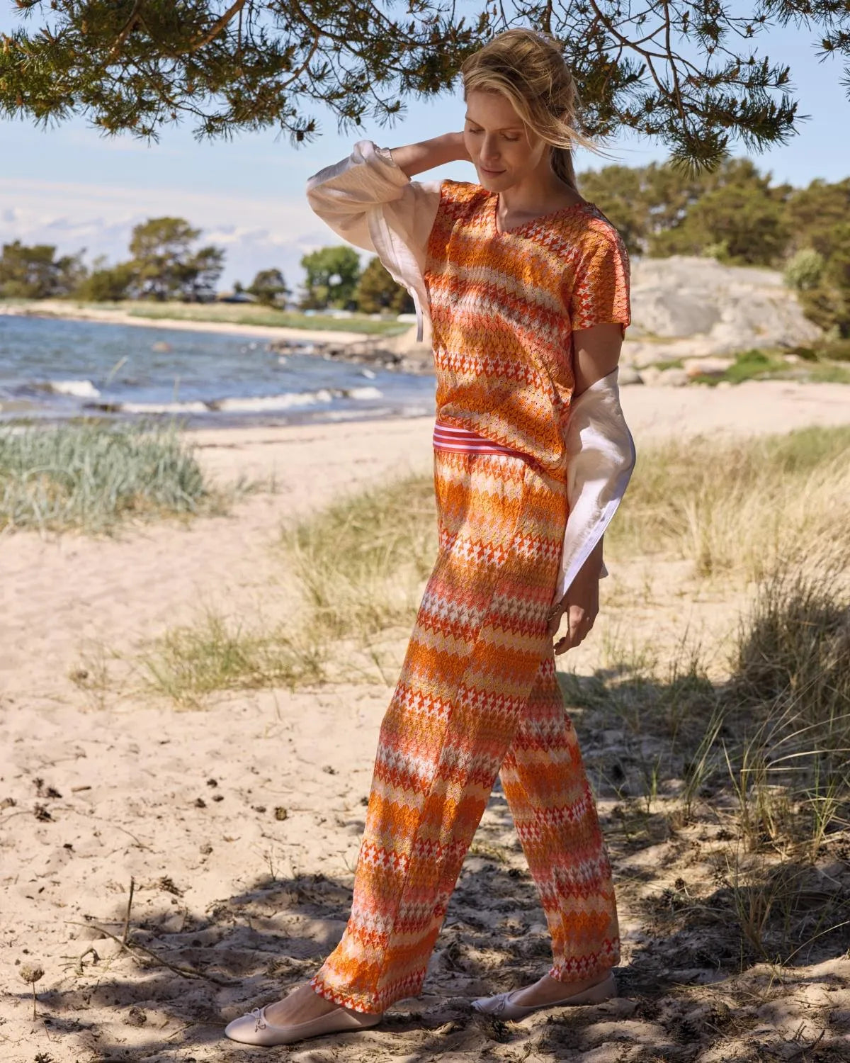 Orange-weiß gemusterter Jumpsuit mit kurzen Ärmeln.