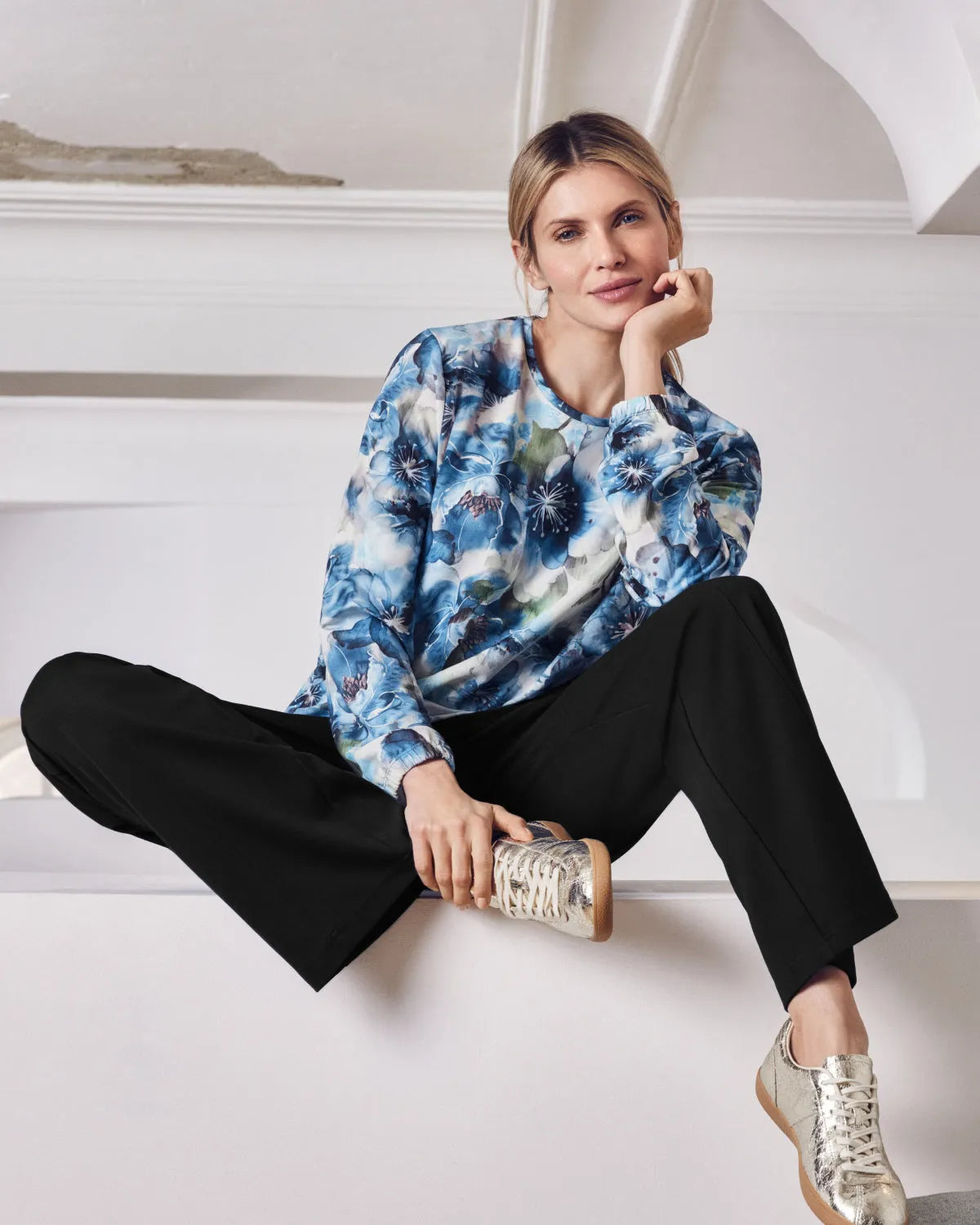 Blaues langärmeliges Damen-Top mit Blumendruck.