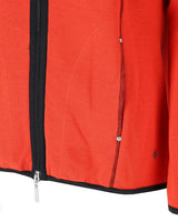 Rote Reißverschlussjacke mit schwarzem Reißverschluss und Zierleiste, strukturierter Stoff.
