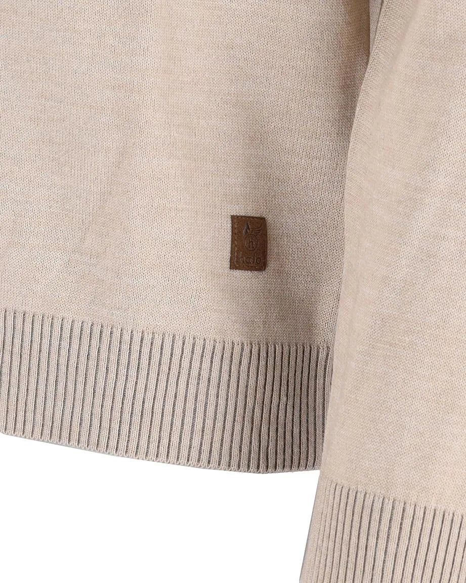 Beigefarbener Pullover mit gerippten Abschlüssen und einem braunen Lederanhänger.