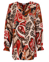 Abstrakt gemusterte Bluse in Beige und Rot mit langen Ärmeln.
