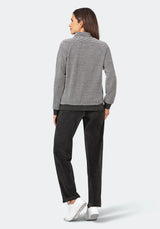 Gestreifter Pullover mit schwarzer Hose und weißen Sneakers.