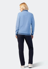 Hellblaues Sweatshirt mit Reißverschluss, marineblaue Hose und weiße Turnschuhe.