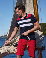 Marineblaues Poloshirt mit roten und weißen Streifen, kurze Ärmel, Material: Baumwolle.