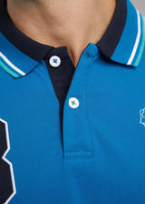 Blaues Poloshirt mit weißem und schwarzem Besatz, Button-down-Kragen, kurze Ärmel.