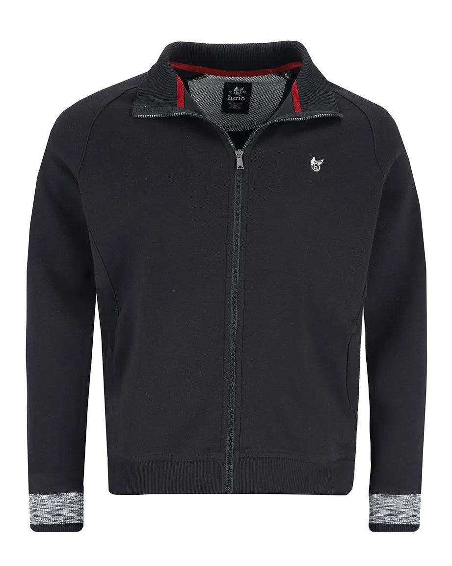 Schwarze Jacke mit Reißverschluss, roten und weißen Akzenten, strukturierten Bündchen und einem Logo auf der Brust.