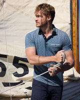 Blaues und graues Poloshirt mit Taschendetail, marineblaue Hose.
