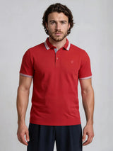 Rotes poloshirt capacity pique mit kurzen ärmeln und weißem besatz an kragen und armabschlüssen mit sticklogo