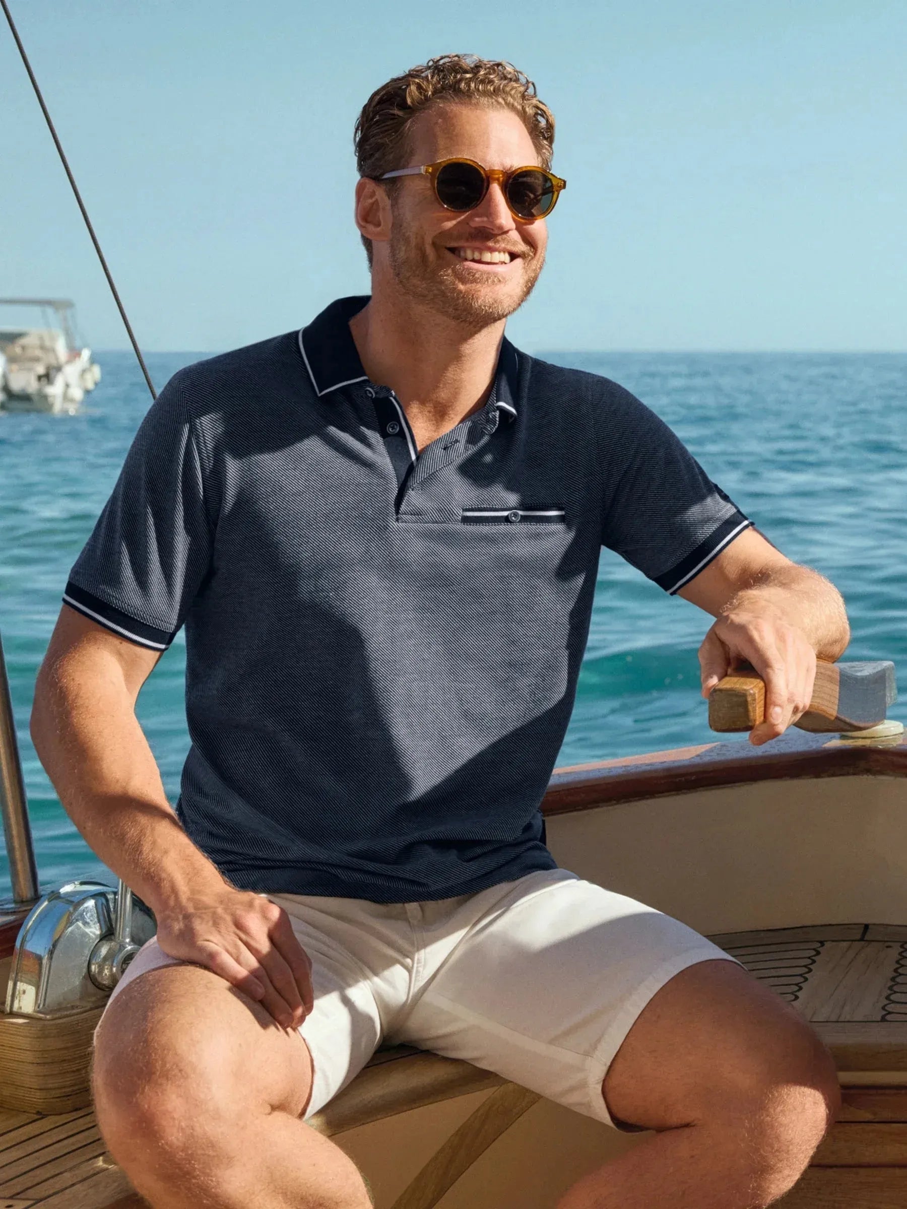 Marineblaues Poloshirt mit diagonalem Jacquardmuster, weißem Kragen- und Ärmelbesatz