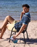 Blau-weiß gestreiftes Poloshirt mit gelben Shorts, lässiges Beachwear-Design.