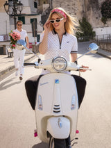 Cremeweiße Vespa mit Chromakzenten und rosa Hinterradkappe