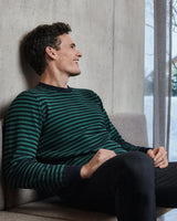 Grün und schwarz gestreifter Pullover mit gerippten Bündchen und Saum, wahrscheinlich aus Baumwolle oder Wolle.