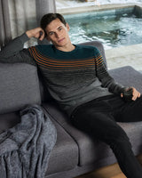 Gestreifter Pullover mit Akzenten in Petrol, Grau und Orange.