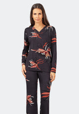 Zweiteiliges Pyjama-Set für Damen mit einem schwarzen, langärmeligen Oberteil mit V-Ausschnitt und einer dazu passenden Hose, beide mit einem lebhaften Blumenmuster in Rot-, Weiß- und Brauntönen verziert.