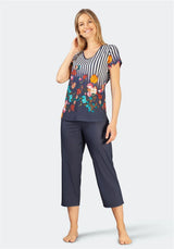 Gestreifter Schlafanzug mit Blumendruck, marineblauer Hose und buntem Blumenmuster auf dem Oberteil.